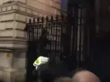 Un hombre trata de saltar una verja de seguridad en Downing Street.