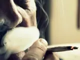 Un hombre fumando un porro.