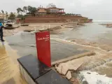 Varias personas observan los daños causados en la Playa Cala Bosque, La Zenia, Orihuela tras las fuertes lluvias registradas.