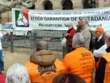 La asamblea de la Marea Pensionista delante del Parlament para reclamar una mejor aplicación de la RGC, con su portavoz, Diosdado Toledano, hablando ante una pancarta.