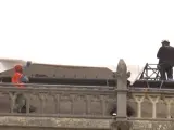 Varios operarios protegen la catedral de Notre Dame con una lona gigante.