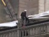 Un operarios colocan una de las lonas gigantes sobre una de las bóvedas derruidas tras el incendio en Notre Dame.