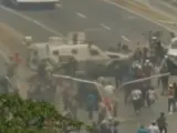 Una tanqueta del Ejército de Venezuela pasa por encima de los manifestantes pro-Guaidó, cerca de la base militar de La Carlota.