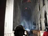 Interior de la catedral de Notre Dame, con las llamas aún visibles sobre el techo.