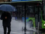 Un hombre se protege de la lluvia en San Sebastián.