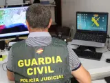 Un agente de la Guardia Civil inspecciona archivos en un ordenador.