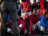 Un grupo de inmigrantes es custodiado por la Policía Nacional en el puerto de Algeciras en 2018.