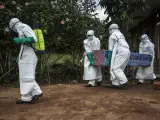 Personal sanitario carga con el ataúd de una víctima de ébola en la República Democrática del Congo.