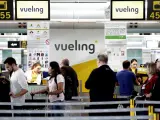 Un grupo de pasajeros ante un mostrador de facturacion de Vueling en el Aeropuerto de Barcelona-El Prat el pasado 25 de abril ( EFE/ Alberto Estévez)
