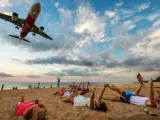 Aviones sobre turistas en la playa de Nai Yang.