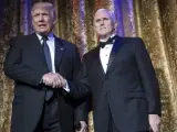 El presidente electo de EE UU Donald Trump (i) saluda al vicepresidente electo Mike Pence (d), durante la Chairman's Global Dinner en el auditorio Andrew W. Mellon, en Washington.