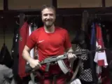 Saveli Kononov, jugador ruso de hockey sobre hielo, posa orgulloso con su premio por ser nombrado mejor jugador del partido: un fusil AK47.