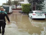 Un agente camina en una carretera afectada por una inundación en el sur de Mallorca.