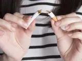 Imagen de recurso de una mujer rompiendo un cigarrillo.