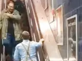 Un hombre ebrio trata de subir por las escaleras mecánicas del metro de Múnich.