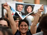 Una simpatizante de la coalición Frente de Todos celebra en Buenos Aires los resultados de las elecciones argentinas, mostrando imágenes del vencedor, el candidato peronista Alberto Fernández, y de la expresidenta Cristina Fernández de Kirchner.