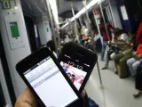 Imagen de archivo de personas mirando sus teléfonos móviles en el metro.