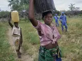Adolescentes se dirigen al río más cercano a proveerse de agua. Tienen que circular por un estrecho camino en una zona repleta de minas, en Inhambane (Mozambique).