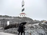 Dos personas caminan por las inmediaciones del faro de Fav&aacute;ritx, en el municipio de Mah&oacute;n.