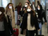 Viajeros procedentes de Italia protegidos con mascarillas a su llegada al aeropuerto de Manises (Valencia).