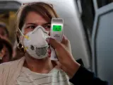 Médicos toman la temperatura a pasajeros en el aeropuerto La Aurora, en Ciudad de Guatemala.