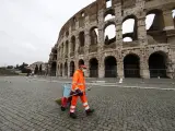 Un barrendero con mascarilla frente al Coliseo de Roma.