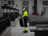 Un trabajador de la limpieza trabaja protegido con una mascarilla.