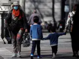 Una mujer con mascarilla junto a dos niños.