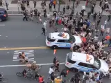 Dos coches de policía atropeyando a los manifestantes.