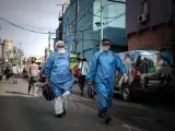 Trabajadores sanitarios con trajes de protección por la pandemia del coronavirus, en la Villa 31 de Buenos Aires (Argentina).
