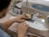 Una mujer fabricando mascarillas