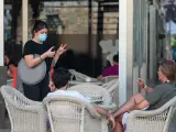 Diverses persones demanen consumicions en una terrassa en el Mercat de Colón durant la fase 2 de la desescalada en la pandèmia de coronavirus COVID19. A València, Espanya, a 3 de juny de 2020.