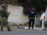 Integrantes de la Guardia Nacional, la Polic&iacute;a Estatal y los Servicios Periciales revisan el cuerpo de un hombre asesinado en una calle de Apaseo El Alto, en el estado de Guanajuato (M&eacute;xico).