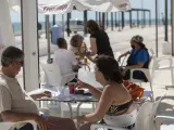 Varias personas en un bar del paseo marítimo de la playa de Matalascañas en Huelva en una imagen de archivo.