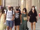 Varias personas con mascarilla pasean por la calle.