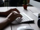 Una persona escribe sobre el teclado de un ordenador.