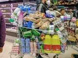 Un cliente realiza la compra en un supermercado un día marcado por colas de gente al inicio de la pandemia.