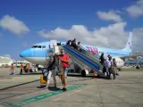 Varios turistas descienden en España de un avión operado por TUI.