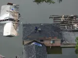 Dos vecinos esperan ser rescatados de un tejado en los días siguientes al paso del 'Katrina' por Nueva Orleans.