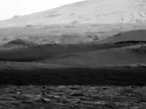 Un diablo de polvo pasa frente al rover Curiosity en Marte