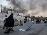 Una mujer arrastra un colchón tras huir del campo de refugiados de Moria, en Lesbos (Grecia), arrasado por varios incendios.