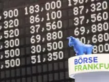 Vista del muñeco de un toro junto a los resultados de los índices en la Bolsa de Valores de Fráncfort, en la sede de Deutsche Boerse, en Fráncfort (Alemania).
