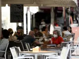 Varias personas disfrutan en una terraza de un bar el día en el que entra en vigor en la Comunidad de Madrid la ampliación del uso obligatorio de la mascarilla