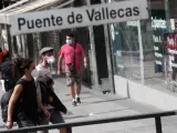 Vecinos pasean al lado del metro de Puente de Vallecas, en Madrid