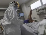 Personal sanitario totalmente protegido atiende a un paciente ingresado en la Unidad de Cuidados Intensivos del Hospital Infanta Sofía