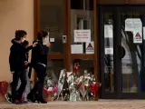 Niños y padres depositan flores frente a la escuela en la que trabajaba como profesor Samuel Paty, decapitado por un extremista islámico.