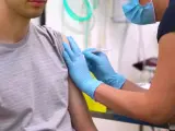 Un joven es vacunado frente al coronavirus.