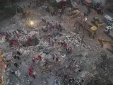 Una foto aérea hecha con un dron muestra a los equipos de rescate buscando supervivientes en un edificio derrumbado tras el terremoto en Esmirna, Turquía.