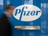 Un hombre camina ante el logo de Pfizer, en Berlín.