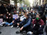Varias personas participan en una concentración contra un desahucio en la calle Luna de Madrid.